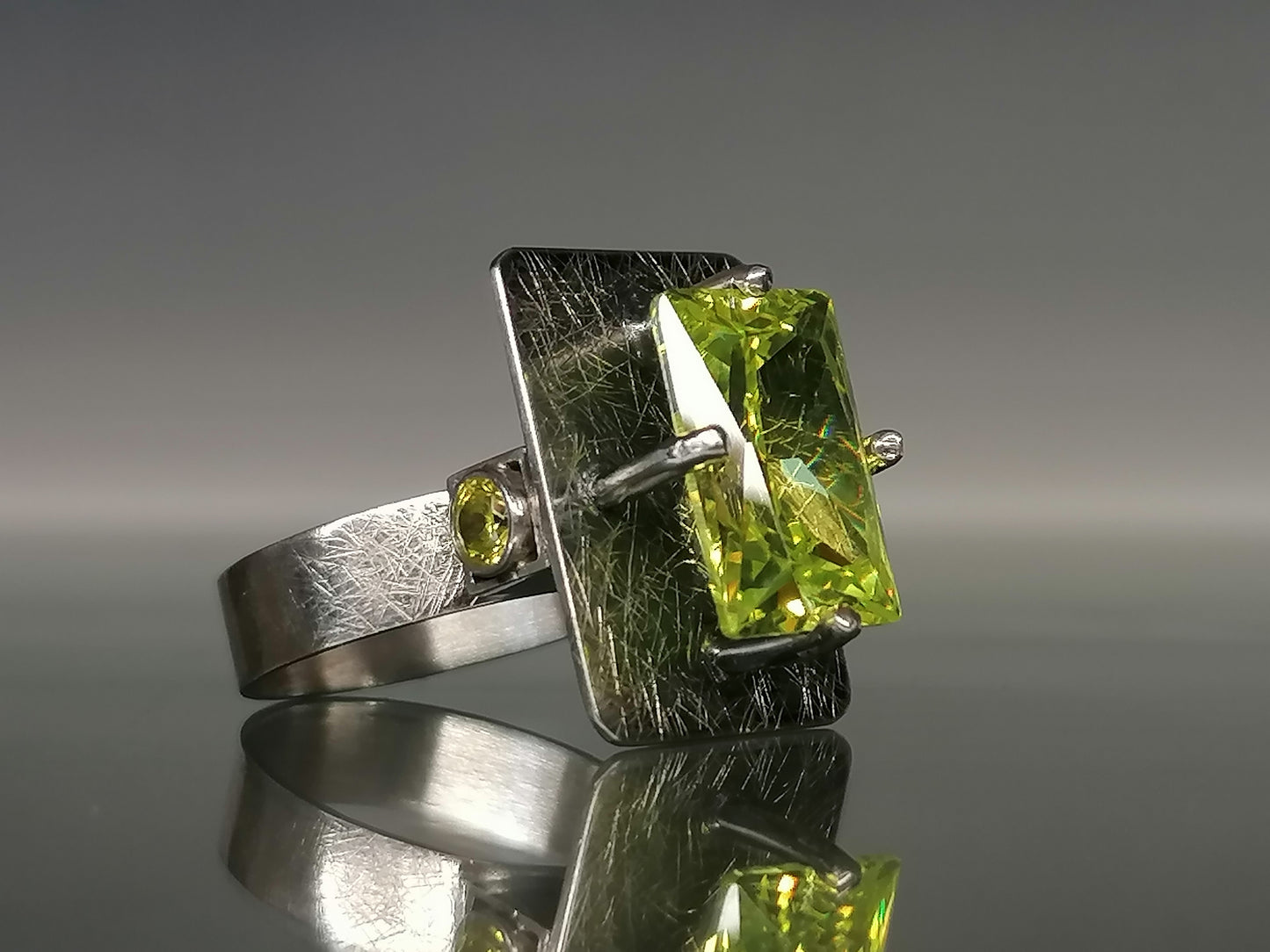 Moderner Ring mit einem grünen Stein