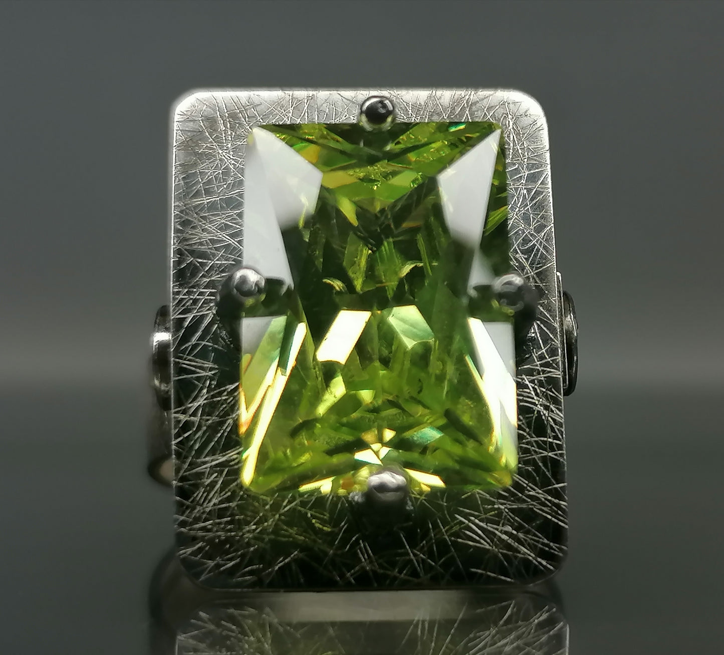 Moderner Ring mit einem grünen Stein